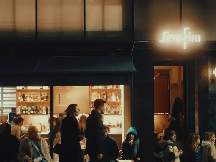 Entrada de um bar cheio, à noite